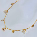 Camille | Collar con dijes bolsitas dorado